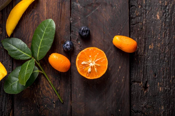 Φρέσκα εσπεριδοειδή, mango blueberry, bay, τοποθετημένα σε ξύλινο τραπέζι — Φωτογραφία Αρχείου