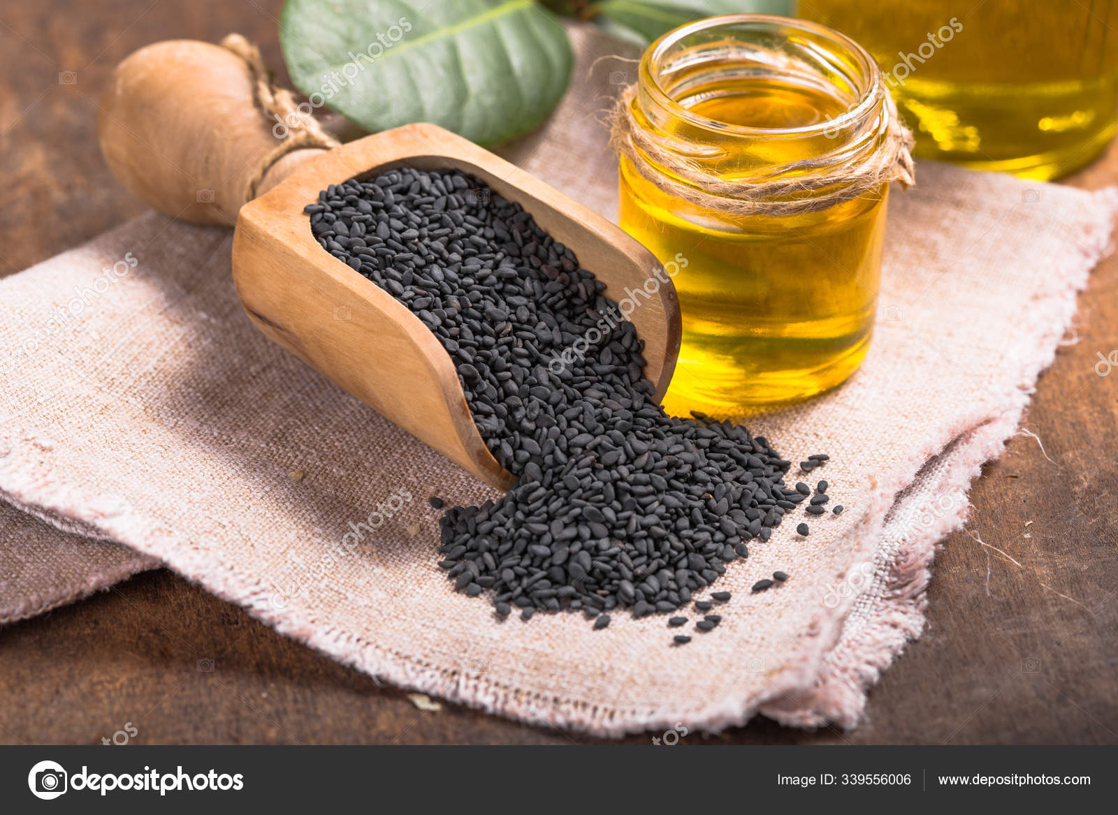 Black sesame and oil on old wooden background — Stock Photo © sokor