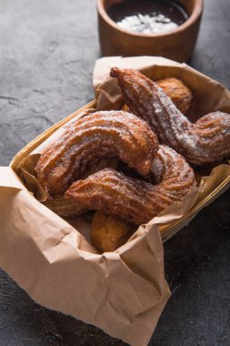 Çikolata soslu ve şekerli kâğıt torba içinde Churros.
