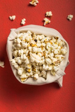 Kırmızı arka planda torbadan taze patlamış mısır döküldü. Sinema