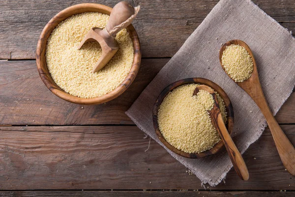 Couscous crudo in una ciotola di legno sul tavolo — Foto Stock