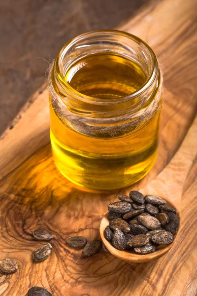 Semillas de sandía aceite y semillas crudas sobre fondo de madera . — Foto de Stock