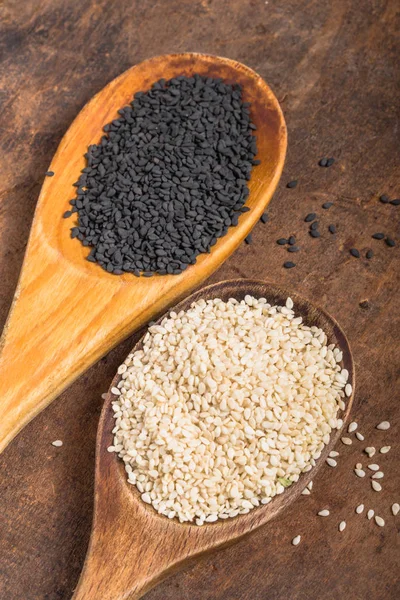 White and black sesame seeds in  spoons on wooden  background, t — 스톡 사진