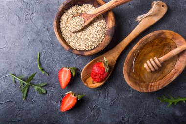 Quinoa White grains in a wooden bowl and spoon with strawberry, 
