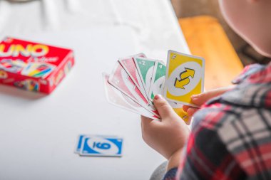 Kiev, Ukrayna - Jeniaury 31. 2020: Uno kartları elinde küçük çocuk; Amerikan kart oyunu