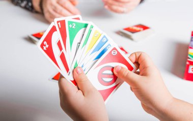 Kiev, Ukrayna - Jeniaury 31. 2020: Uno kartları elinde küçük çocuk; Amerikan kart oyunu