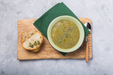 Brokoli çorbası püresi üzerine kızarmış baget ve zeytinyağı ile servis edilir. Tahta tahta bir görünüm üzerinde, düz döşeme, kopyalama alanı