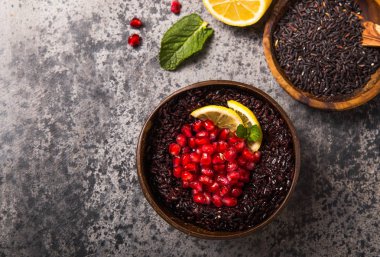 Tayland usulü siyah yasemin pilavı, chia tohumu, nar, limon, beton grisi arka planda susam. Üst görünüm kopyalama fidanı
