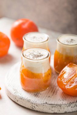 Hurmalı Chia pudingi. Sonbahar ya da kış tatlısı. Açık gri arkaplan. Sağlıklı vegan, vejetaryen kahvaltı masası.