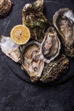 Taze açık istiridye. Sağlıklı deniz ürünleri. Restoranda akşam yemeği. Gurme yemeği. Karanlık arka plan. Üst görünüm