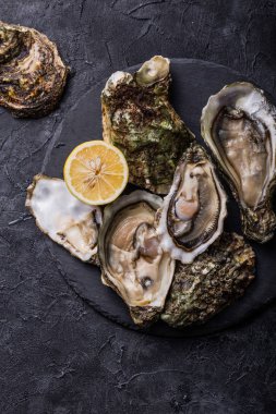 Taze açık istiridye. Sağlıklı deniz ürünleri. Restoranda akşam yemeği. Gurme yemeği. Karanlık arka plan. Üst görünüm