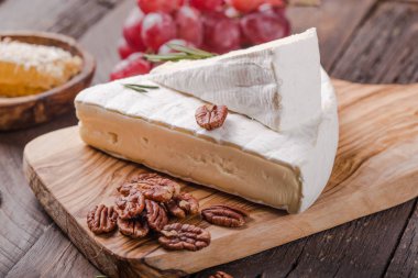 Brie peyniri ya da yumuşak inek dilimi - Fransız peyniri üzümlü, bal peteği ve cevizli ahşap panoda..