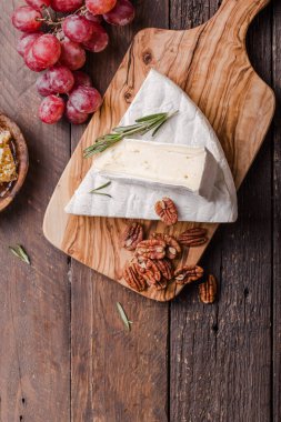 Brie peyniri ya da yumuşak inek dilimi - Fransız peyniri üzümlü, bal peteği ve cevizli ahşap panoda..