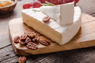 Brie peyniri ya da yumuşak inek dilimi - Fransız peyniri üzümlü, bal peteği ve cevizli ahşap panoda..