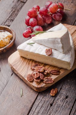 Brie peyniri ya da yumuşak inek dilimi - Fransız peyniri üzümlü, bal peteği ve cevizli ahşap panoda..