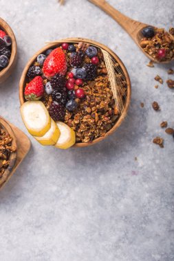Morning Granola, Fruits, gri beton arka planda kasede meyveler. Sağlıklı kahvaltı gevrekleri. Diyet yapma kavramı, sağlıklı ve temiz yemek.