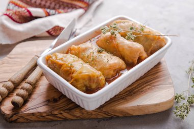 Beyaz bir tabakta lahana rulosu içinde et ve arka planda da sos. Asya mutfağı manzaralı. Rus yemeği