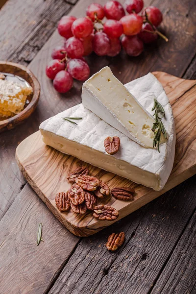 Brie peyniri ya da yumuşak inek dilimi - Fransız peyniri üzümlü, bal peteği ve cevizli ahşap panoda..