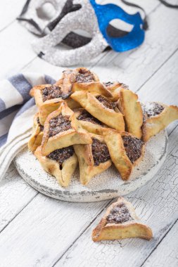 Geleneksel Yahudi Hamantaschen kurabiyeleri, kurutulmuş kayısılar, hurma. Purim kutlaması konsepti. Karnaval tatil geçmişi. Seçici odaklanma. Boşluğu kopyala.