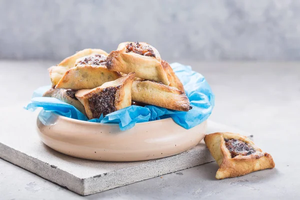 Geleneksel Yahudi Hamantaschen kurabiyeleri, kurutulmuş kayısılar, hurma. Purim kutlaması konsepti. Karnaval tatil geçmişi. Seçici odaklanma. Boşluğu kopyala.