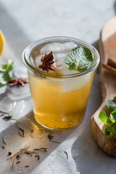 Kombucha Tea or iced tea beverage. Fermented Super Food, Pro Biotic summer  drink In Glass with mint , Lemon, On concrete  Table, outdoor. Copy space.