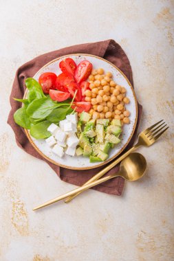 Avokado, nohut, feta peyniri, taze ıspanak, domates ve bir bardak suyla Buda Kasesi. Sağlıklı vejetaryen detoks dengeli yemek kavramı. Üst Manzara. Boşluğu kopyala.
