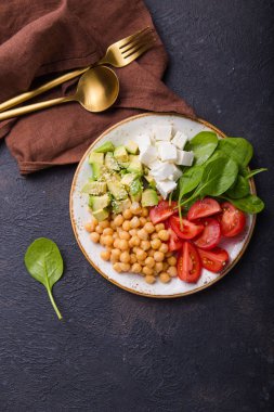 Avokado, nohut, feta peyniri, taze ıspanak, domates ve bir bardak suyla Buda Kasesi. Sağlıklı vejetaryen detoks dengeli yemek kavramı. Üst Manzara. Boşluğu kopyala.