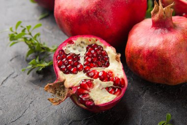 Siyah taş bir masada sulu ve olgun nar. en üstteki görünüm