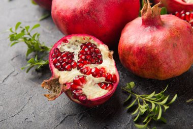 Siyah taş bir masada sulu ve olgun nar. en üstteki görünüm