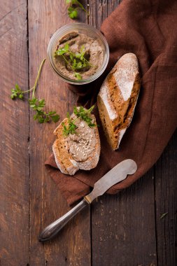 Taze ev yapımı tavuk ciğeri ekmeğin üzerinde ezme ve koyu ahşap bir arka planda kavanozda.