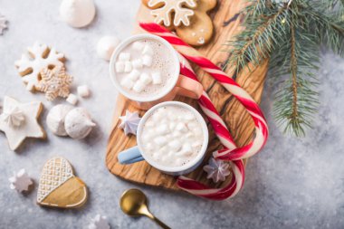 Sıcak çikolatalı kakao, gri arka planda noel renkli kupalarla marshmallowlu içecek. Geleneksel sıcak içecek, Noel 'de ya da Yeni Yıl' da festival kokteyli.