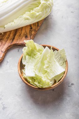 Beyaz arka planda ahşap kasede taze Çin lahanaları pişirmek. en üstteki görünüm