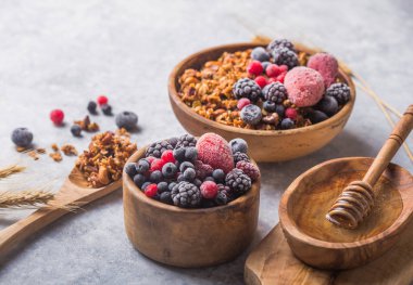 Morning Granola, Fruits, gri beton arka planda kasede meyveler. Sağlıklı kahvaltı gevrekleri. Diyet yapma kavramı, sağlıklı ve temiz yemek.