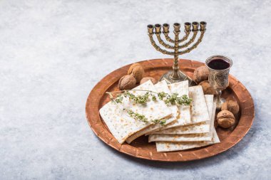 Hamursuz Bayramı, mayasız ekmek ziyafeti, matzah ekmeği ve parlak metal tepside kırmızı şarap kadehleri..