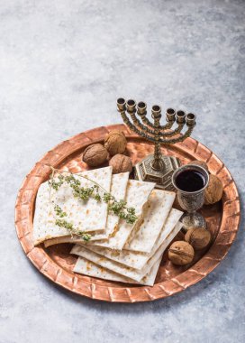 Hamursuz Bayramı, mayasız ekmek ziyafeti, matzah ekmeği ve parlak metal tepside kırmızı şarap kadehleri..