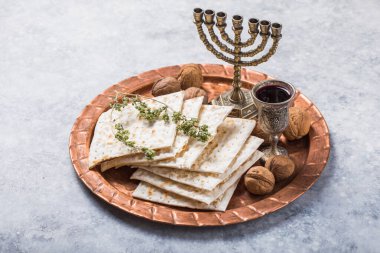 Hamursuz Bayramı, mayasız ekmek ziyafeti, matzah ekmeği ve parlak metal tepside kırmızı şarap kadehleri..