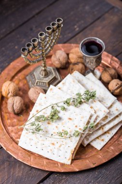 Hamursuz Bayramı, mayasız ekmek ziyafeti, matzah ekmeği ve parlak metal tepside kırmızı şarap kadehleri..
