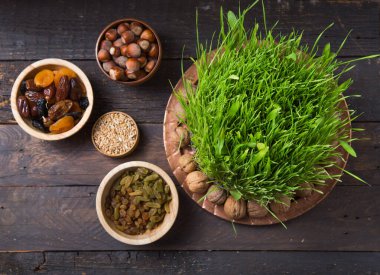 Nowruz tatilin kutlu olsun. Çeşitli kurutulmuş meyve, fındık, tohum, yeşil çimen buğdaylı açık arkaplan, kopya alanı üst görünümü kutlamaları