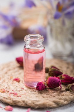 Doğal saf gül yağı ya da spa, cilt bakımı ya da pembe güllü aromaterapi için kokulu su. Organik kozmetik konsepti. Seçici odak