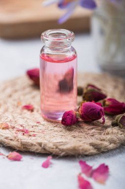 Doğal saf gül yağı ya da spa, cilt bakımı ya da pembe güllü aromaterapi için kokulu su. Organik kozmetik konsepti. Seçici odak