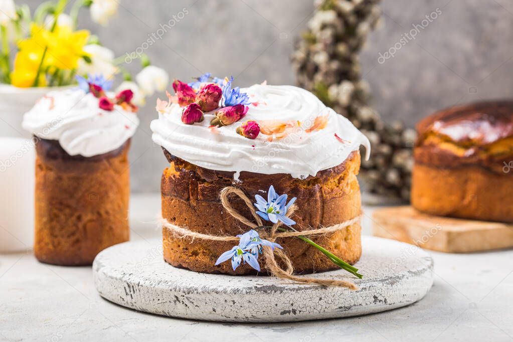 Easter Cake - Russian and Ukrainian Traditional Kulich or Brioche on a light stone background. Paska or Panettone Bread  and spring flowers