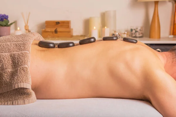 Uomo Con Pietre Sul Lettino Massaggio Centro Benessere Con Trattamento — Foto Stock