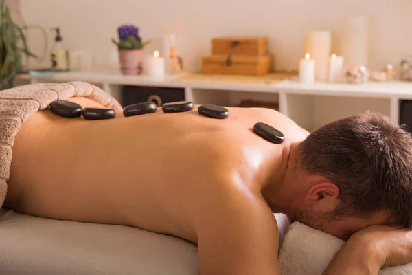 Man Met Stenen Massagetafel Spa Met Lichaamsbehandeling Persoon Liggend Ontspannend — Stockfoto