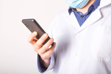 Tıbbi hizmetlerin sağlanmasında mobil cihazlara yardım etme kavramı. Doktor beyaz arka planda bir telefonda çalışıyor. Boşluğu kopyala