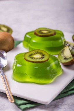 Lezzetli taze iki yeşil jöle ve beton masa üzerinde kivi dilimleri.