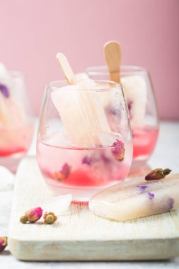 Renkli yiyecekler. Kokteyl bardakları pembe gül şampanyası, ya da limonata ile kuru gül tomurcukları, buz.