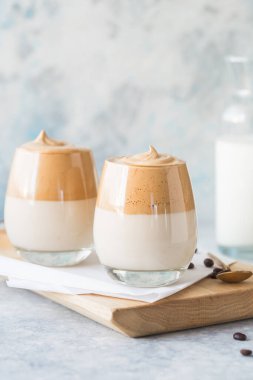 Dalgona Köpüklü Kahve, krem şantili kahve, şeker ve sütle birlikte hafif beton masada bulunan bir Güney Kore içeceğidir.