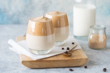 Dalgona Köpüklü Kahve, krem şantili kahve, şeker ve sütle birlikte hafif beton masada bulunan bir Güney Kore içeceğidir.