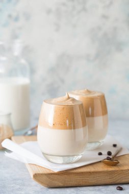 Dalgona Köpüklü Kahve, krem şantili kahve, şeker ve sütle birlikte hafif beton masada bulunan bir Güney Kore içeceğidir.