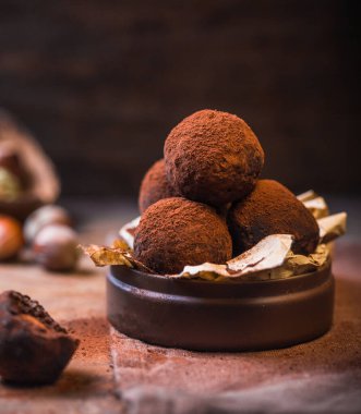 Ev yapımı çikolatalı trüf mantarları ahşap masa yakın görüntüsünde. Lezzetli vejetaryen şekeri ya da çiğ kakao tozlu toplar